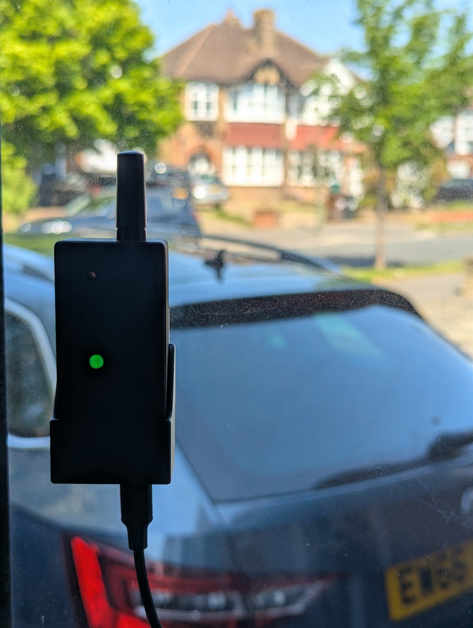 JamFinder mounted in a front-facing window, protecting a car parked on the driveway